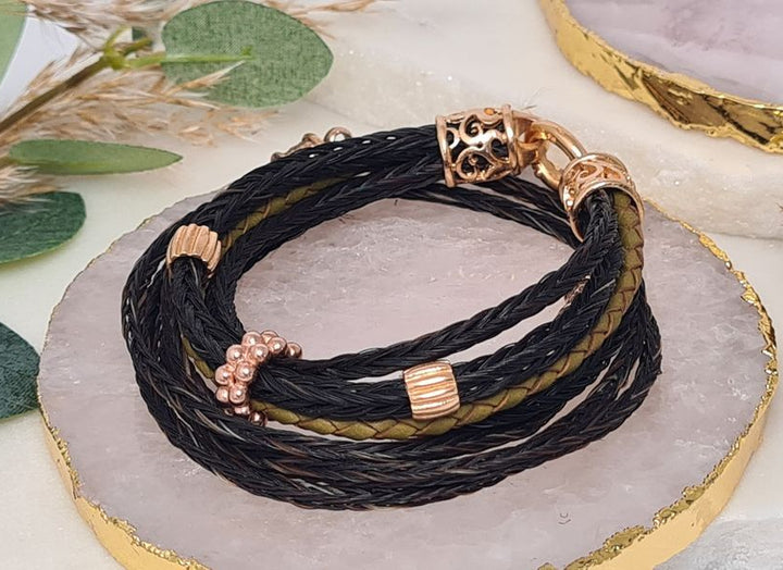 Pferdehaararmband mit schwarzem Pferdehaar und grünem Leder und gelbgpld vergoldeten Endkappen 